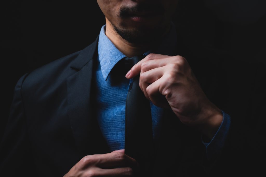 business man in black suit and adjusting his necktie